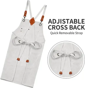 Thick canvas work apron with adjustable cross back straps, durable leather and metal hardware details.