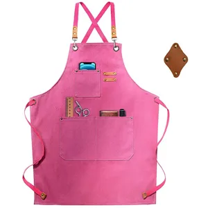 Pink canvas work apron with cross back straps and multiple utility pockets for kitchen gardening.