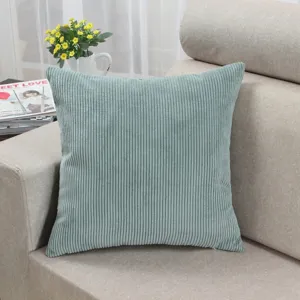 Close-up view of a soft light blue corduroy throw pillow texture placed on a cozy sofa.