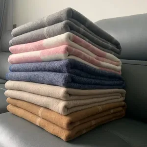 Detailed view of soft wool blend knit sofa throw blanket stacked neatly for home use.