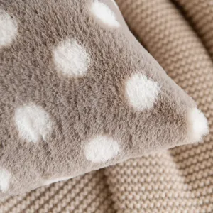 Close-up detail of soft faux fur polka dot pillow, cozy texture for home decor and sofa cushion