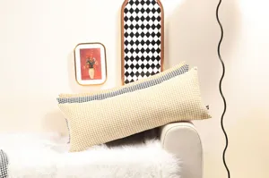 Vue détaillée du long coussin pied-de-poule jaune avec texture douce pour canapé.