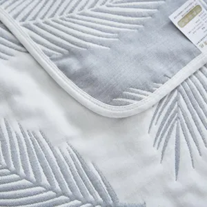 Vue détaillée d'une couverture en gaze de coton pure avec texture douce et bord soigné.
