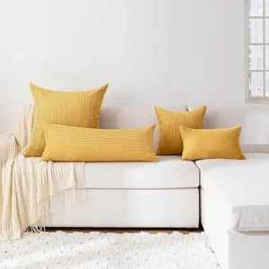Yellow corduroy long body pillow and square cushion set displayed on white couch for home decor.