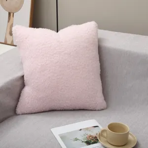 Détail de coussin duveteux rose sur canapé gris, coussin déco confortable pour lit et salon.