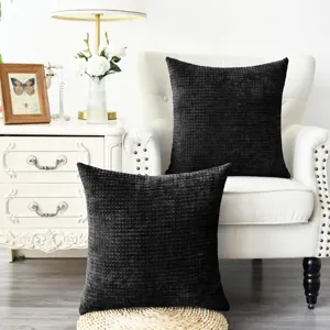 Textured chenille throw pillow cover detail, cozy black sofa cushion in living room setup.