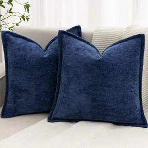 Détail de coussin décoratif en chenille bleu foncé sur canapé, housse de coussin douce.