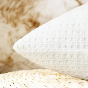 Close-up detail shot of white waffle knit chenille cushion cover fabric texture for home decor.