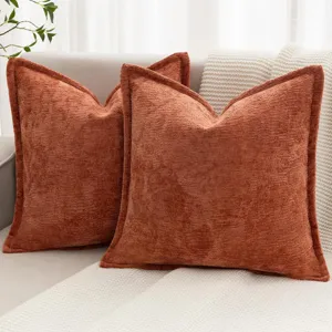 Vue détaillée d'un coussin en chenille orange brûlé pour décoration de canapé de salon.