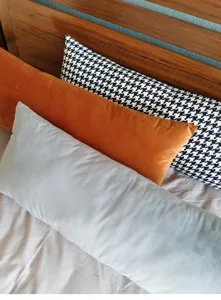 Détail de coussin long avec texture velours douce et motif pied de poule classique pour lit.