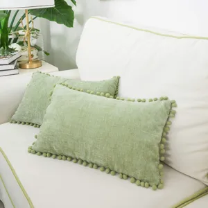Vue detaillee du coussin en chenille epaisse avec pompons, ideal pour une decoration chaleureuse.