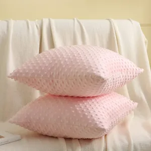 Detailaufnahme von rosa Kissenbezügen mit Soft-Noppen-Struktur für gemütliche Raumgestaltung.