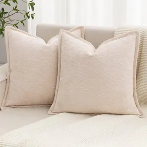 Détail de coussin décoratif beige en chenille douce, accessoire parfait pour canapé cozy.
