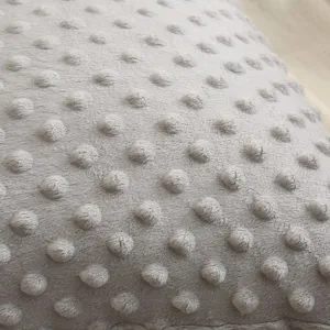 Graues Noppenkissen Detail Nahaufnahme, weicher Plüsch Stoff Textur Bezug für Sofakissen.