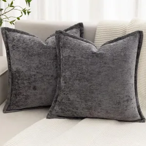 Gros plan détaillé de deux beaux coussins en chenille texturée gris foncé sur canapé.