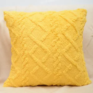 Dettaglio cuscino decorativo in peluche giallo vivo, tessuto morbido, arredo accogliente.