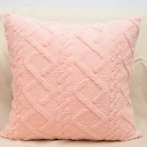 Dettaglio cuscino rosa in soffice peluche, morbido cuscino geometrico per divano e letto.