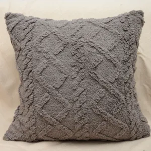 Primo piano dettagliato del cuscino decorativo in peluche grigio scuro con toufting.