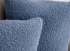 Close-up detail of soft blue teddy fleece pillow cover, cozy fuzzy texture fabric.