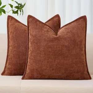 Detailaufnahme eines braunen, strukturierten Kissenbezugs aus Chenille mit Paspelierung, nordisch.