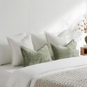 Texturierte Chenille Kissen Detailaufnahme, elegante salbeigrüne und weiße Zierkissen im Bett.
