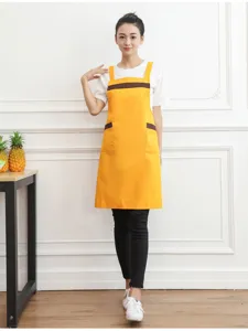 Detailed close-up shot of yellow cotton work apron featuring stylish brown contrast pockets.