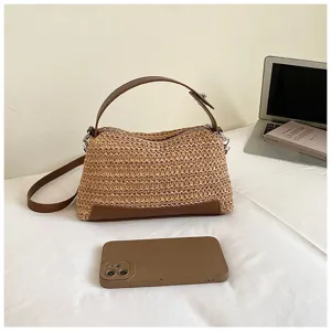 Vista detallada del elegante bolso de hombro de paja de verano con ribetes de cuero sintético marrón.