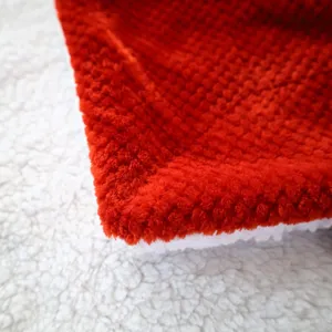 Close-up detail shot of soft red and white double-sided flannel fleece blanket fabric.