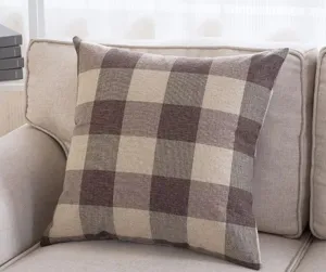 Detailed view of a soft brown and beige plaid cotton linen throw pillow on a cozy sofa cushion.