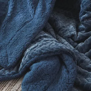 Close-up detail of soft deep blue double-sided plush blanket showing cozy fluffy texture.