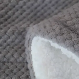 Close-up detail shot of the soft grey flannel and fluffy white sherpa blanket texture.