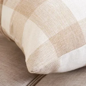 Close-up detail of beige cotton linen plaid cushion fabric texture and neat stitching.