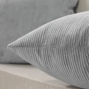 Close-up detail of grey corduroy pillow fabric texture, showing soft ribbed surface.