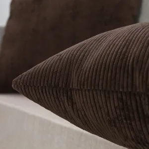 Close-up of a dark brown corduroy throw pillow detail showing soft textured striped fabric.