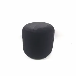 Close-up detail of the black plush round stool showing soft velvet texture and cozy home.