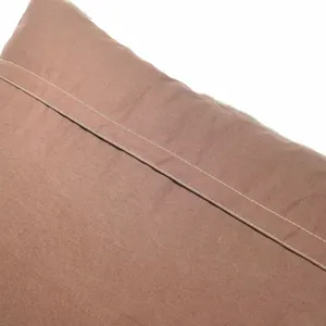 Gros plan detail du dos de coussin en peluche marron avec des coutures soignees et douces