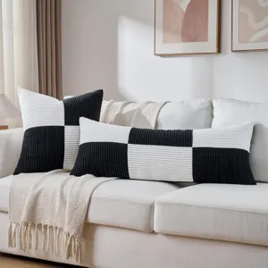 Schwarz-weißer Kord-Zierkissenbezug und langes Kissen für gemütliche Schlafzimmer Dekoration.