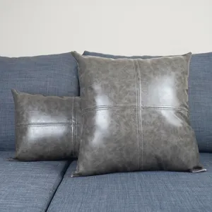 Hauptansicht des stilvollen grauen PU-Leder Kissenbezugs mit Muster auf dem Sofa.