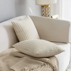Corduroy throw pillow detail scene, soft textured cushion on white sofa, cozy home decor setup.