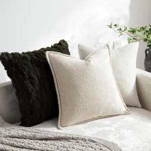 Nahaufnahme von strukturierten Kissen aus Chenille und Plüsch auf einem gemütlichen Sofa.