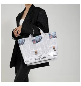Close-up detail van de grote krantenprint tote handtas, modieuze stijl showcase.