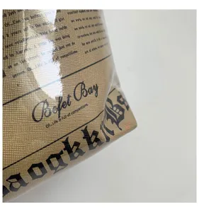 Detailopname van stijlvolle krantenprint totebag met textuur en typografie-ontwerp.