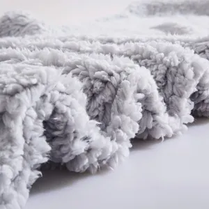 Gros-plan sur le détail du tissu en peluche grise, texture duveteuse douce pour oreiller.