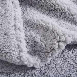 Gros plan detaille de la texture en tissu peluche gris, materiau tres doux pour housse de coussin.
