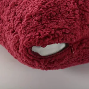 Détail de coussin en polaire sherpa bordeaux, oreiller de dossier de lit texturé doux