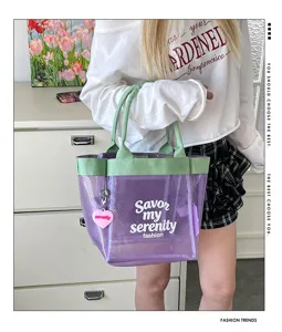 Detailed view of the stylish transparent purple tote bag with green handles and cute charm.