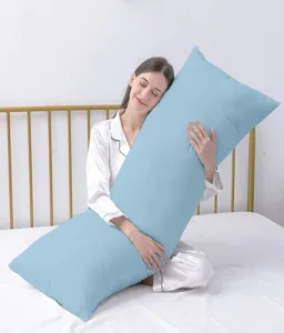 Dettaglio di cuscino lungo blu chiaro comodo che mostra una texture morbida sul letto bianco.