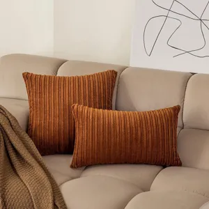 Detail view of brown corduroy throw pillows set, showcasing soft textured fabric on a sofa.