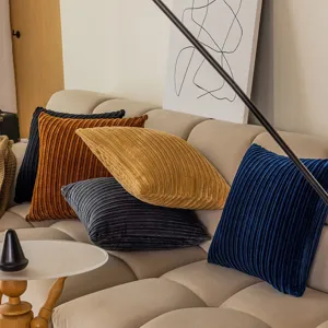 Corduroy throw pillow detail showing soft textured wide stripes on modern sofa scene in cozy room.