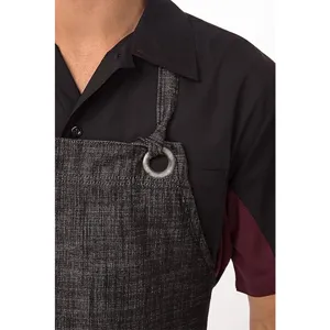 Cotton linen work apron detail view showcasing the textured fabric and metal ring strap connector.